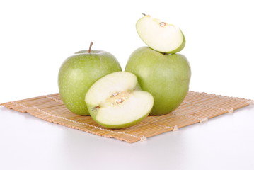 green apples on a bamboo place mat