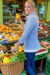 Frau am Obstmarkt mit Einkaufskorb