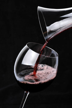 Red Wine pouring into glass from decanter