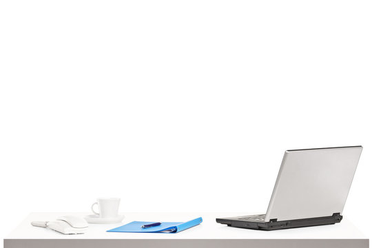 Laptop, cup of coffee and other office objects on a table