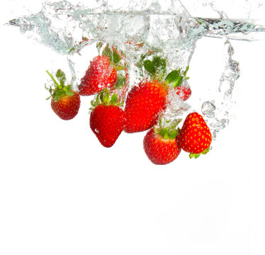 Strawberries being thrown into water
