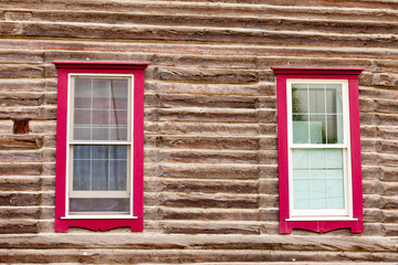Red framed windows in log house wall architecture