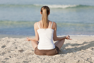 Fototapeta na wymiar Frau macht yoga Sport am Strand Querformat