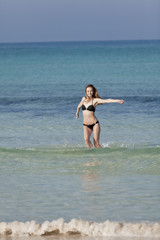 Frau mit Bikini im meer beim Springen Hochformat