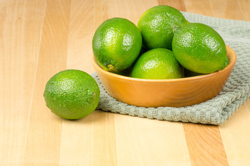 Bowl of limes on green cloth