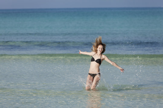 Frau mit Bikini springt im meer Querformat