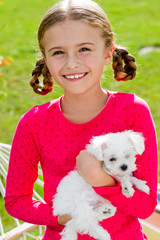 Best friends - happy girl with cute puppy in the garden