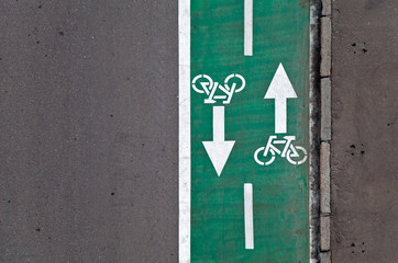 Fototapeta premium Green bicycle lane with road marking background texture