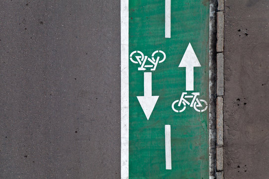 Fototapeta Green bicycle lane with road marking background texture