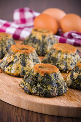 Spinach cakes on wooden cutting board.