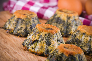 Spinach cakes on wooden cutting board.