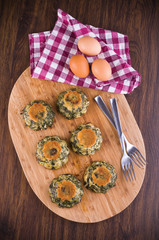 Spinach cakes on wooden cutting board.