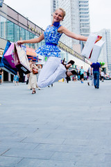 Young and beautiful woman walking down the street with shopping 