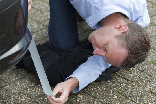 Man Using Duct Tape To Fix Car.