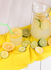 Citrus lemonade in glass and pitcher of citrus around