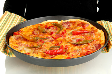 hands holding pepperoni pizza in pan close-up