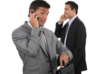Two businessmen making telephone calls