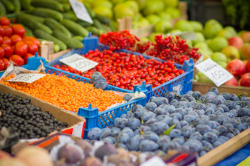 Variety of wild berries on table on city market