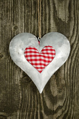 Herz aus Blech auf Holzwand