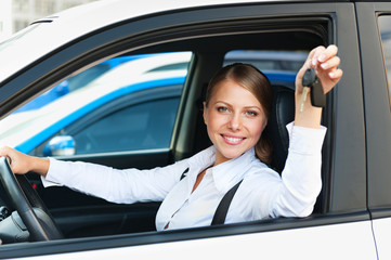 woman sitting in car and showing the car keys