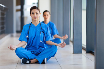 two young healthcare workers meditation during break