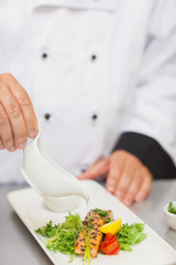 Obraz na płótnie Canvas Chef polewanie sosem łososia
