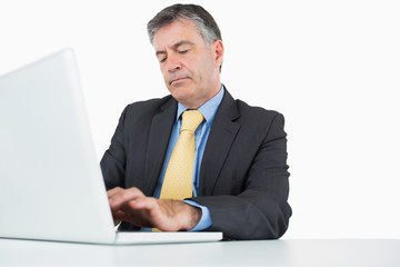 Concentrated man typing on his laptop