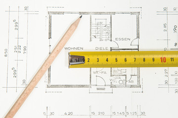Bauplan Eigenheim mit Bleistift und Metermaß
