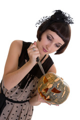 Pretty woman with knife carving a pumpkin isolated