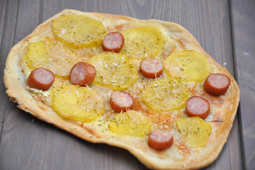 Pizza mit Kartoffeln und Würstchen