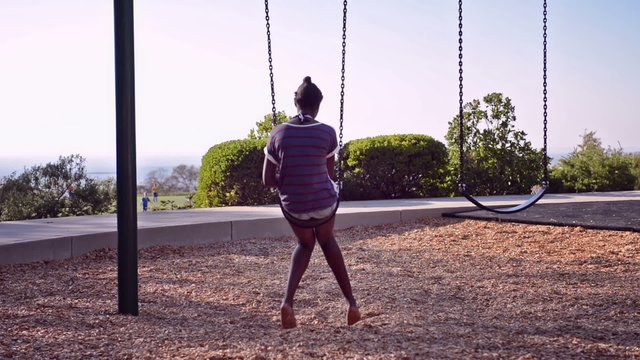 black girl riding a swing