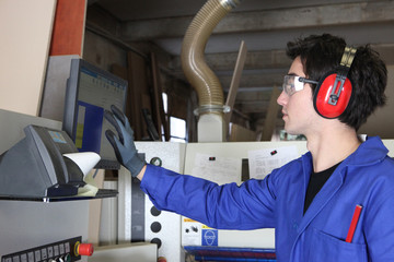 Young man operating factory machinery