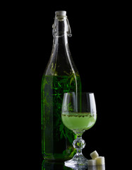 Absinthe with sugar bottle and glass isolated on black