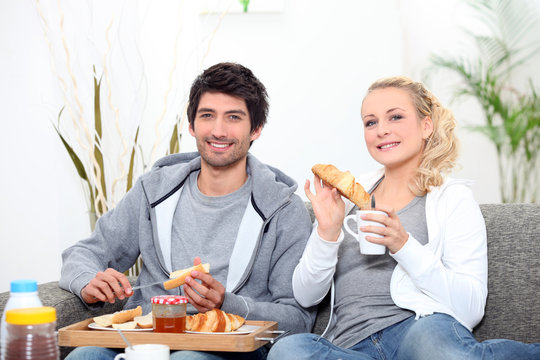 Young Couple Sharing Breakfast In The Lounge