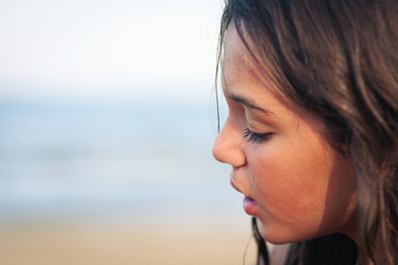 Portrait of young girl on the beach. Shallow depth of field.