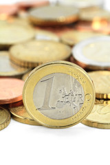 Euro coins. One Euro coin on the foreground. Shallow DOF