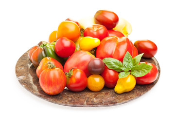 Viele Tomaten auf Teller vor weißem Hintergrund
