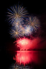 Fototapeta na wymiar Fireworks show above the lake