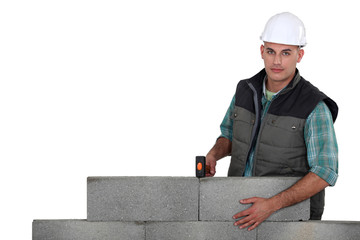 bricklayer posing by concrete wall isolated on white