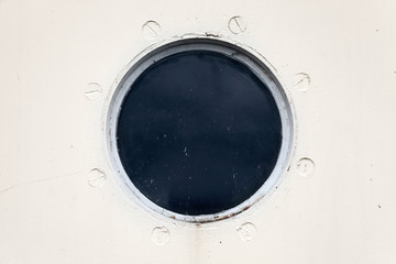 Porthole on the white metal naval wall