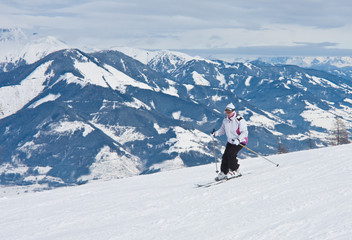 Fototapeta na wymiar Kobieta jest na nartach w ośrodku narciarskim