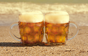 Two glasses of cold beer on the sea beach