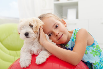 Little girl playing with her small fluffy dog
