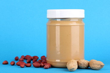 Delicious peanut butter in jar of peanut near on blue