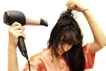 Fototapeta premium The woman dries hair the hair dryer