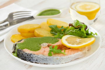 boiled salmon with sauce and potato on the plate