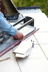 man cutting tile by cutter