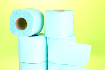 blue rolls of toilet paper on green background