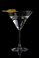 Martini glass and olives isolated on black