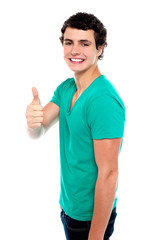 Cheerful teenager showing thumbs up to camera
